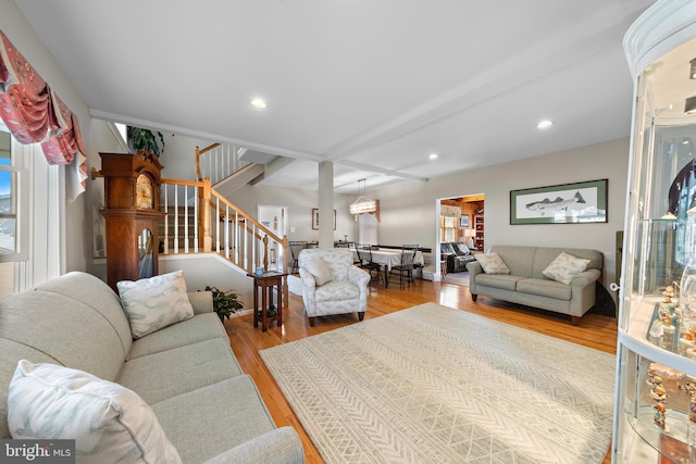 living room featuring beamed ceiling and light hardwood / wood-style flooring