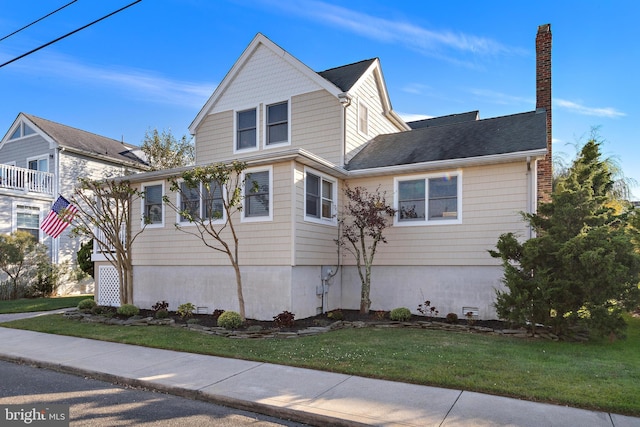 view of front of property with a balcony and a front lawn