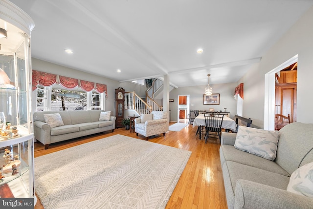 living room featuring lofted ceiling and light hardwood / wood-style flooring