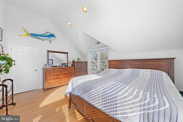 bedroom featuring light wood-type flooring and vaulted ceiling