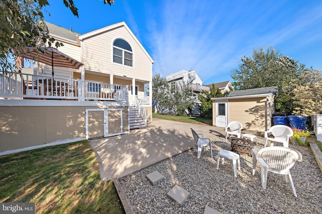 rear view of property featuring a patio, an outdoor fire pit, and a deck