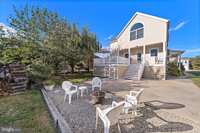 back of property featuring an outdoor fire pit, a porch, and a patio