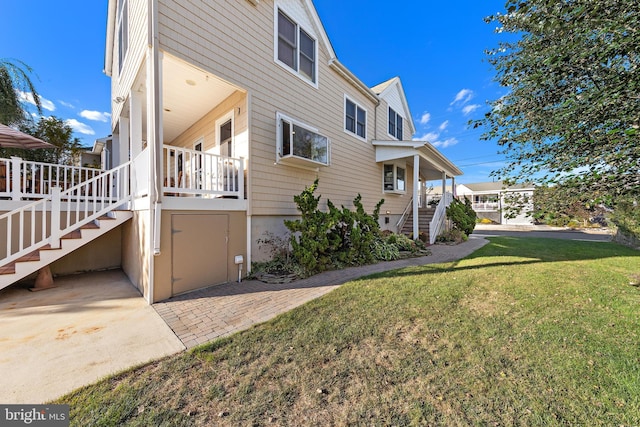 view of side of property with a yard and a patio area