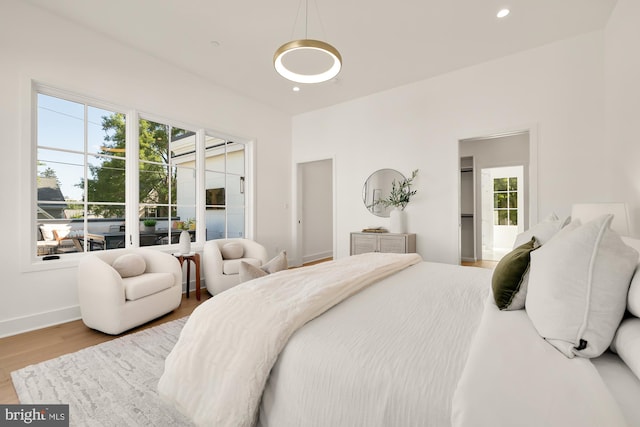 bedroom with multiple windows and light hardwood / wood-style floors