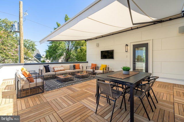 wooden terrace with an outdoor living space