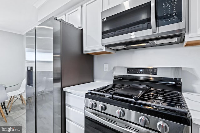 kitchen featuring stainless steel appliances and white cabinetry