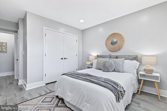 bedroom with a closet and light hardwood / wood-style flooring