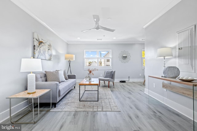 living room with ceiling fan, light wood-type flooring, and crown molding