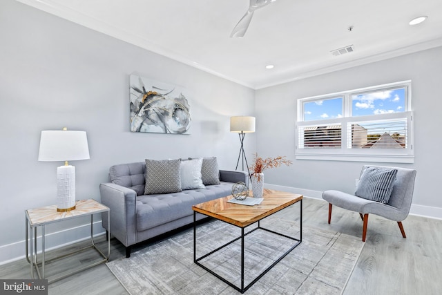 living room featuring crown molding, ceiling fan, and light hardwood / wood-style floors