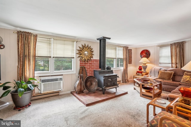 living room featuring a wall mounted AC, a healthy amount of sunlight, a wood stove, and carpet floors