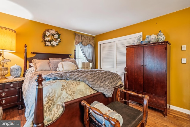 bedroom featuring wood finished floors, baseboards, and a closet
