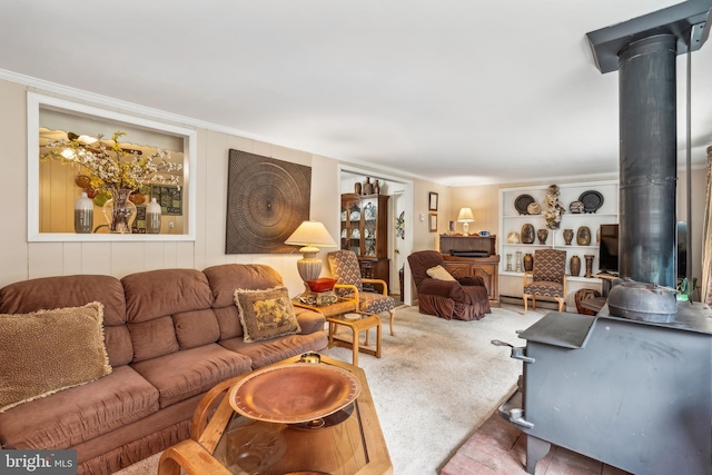 living room with a wood stove and crown molding