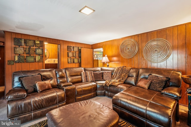 carpeted living area with wooden walls