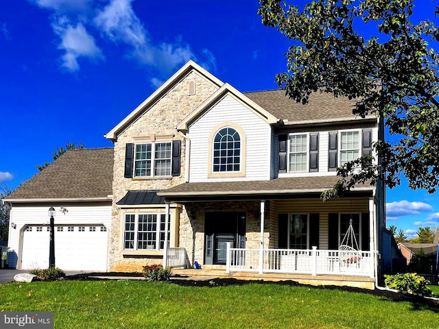 view of front facade with covered porch, a front yard, and a garage