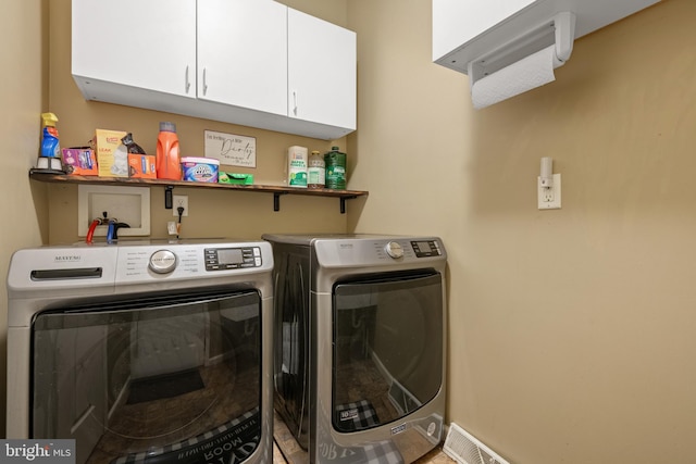 laundry area featuring washer and clothes dryer and cabinets