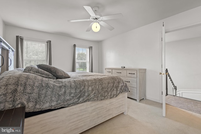 carpeted bedroom with multiple windows and ceiling fan