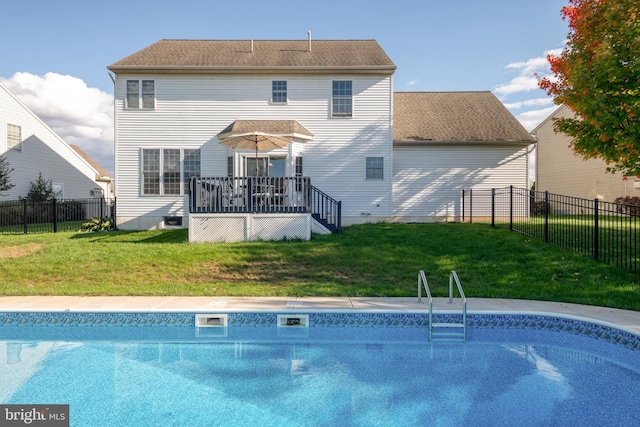 rear view of house featuring a yard and a pool side deck