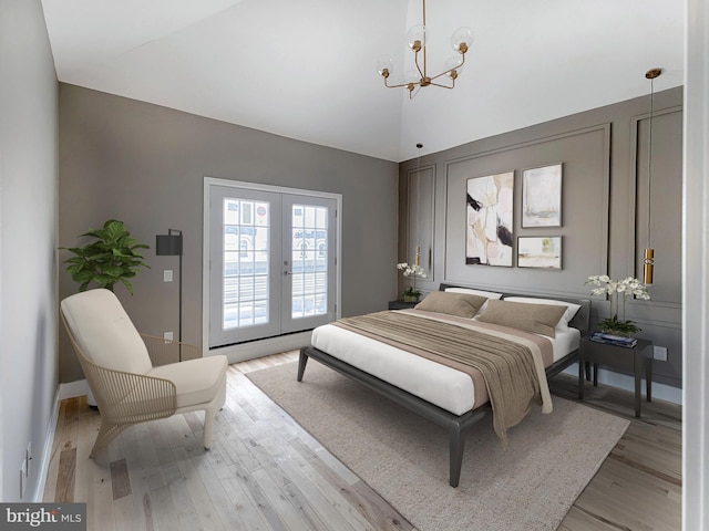 bedroom with a notable chandelier, french doors, vaulted ceiling, and light hardwood / wood-style flooring