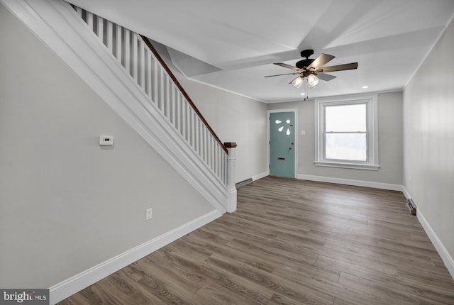 foyer entrance featuring ornamental molding, ceiling fan, and wood-type flooring