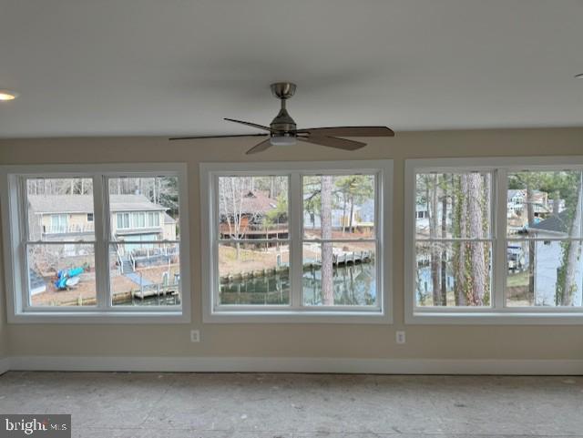 unfurnished sunroom featuring ceiling fan