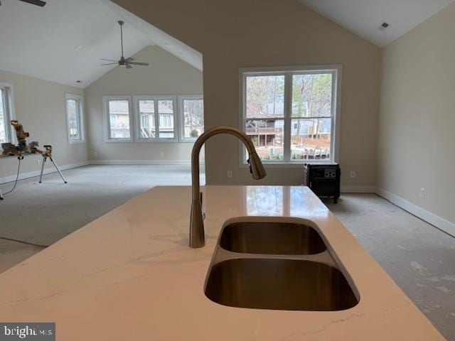 kitchen featuring sink, high vaulted ceiling, light stone countertops, and ceiling fan