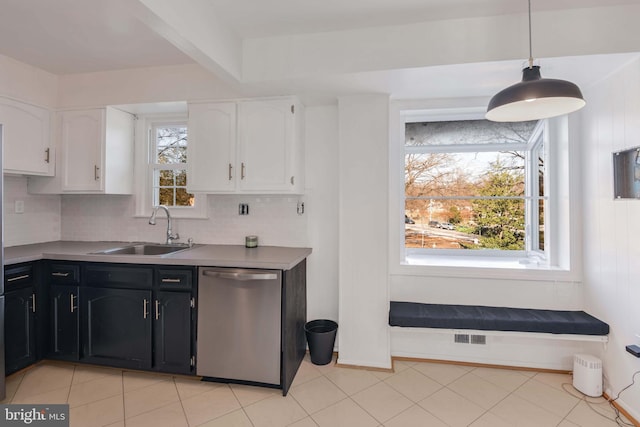 kitchen with sink, white cabinetry, hanging light fixtures, dishwasher, and decorative backsplash