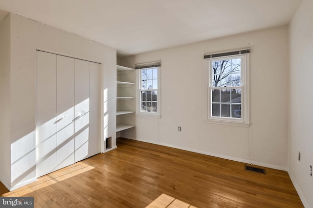 unfurnished bedroom with hardwood / wood-style floors and a closet