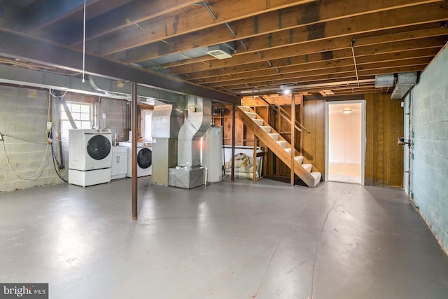 basement featuring heating unit, gas water heater, and washing machine and dryer