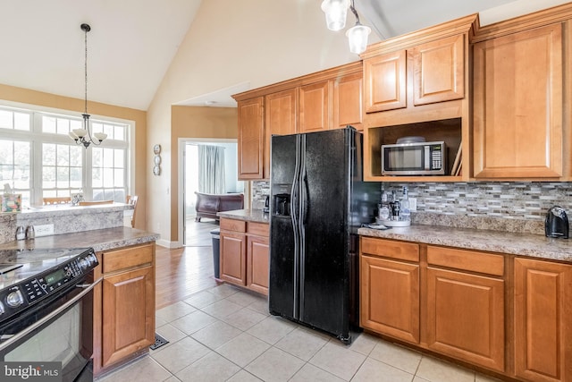 kitchen featuring light tile patterned floors, backsplash, a chandelier, high vaulted ceiling, and black appliances