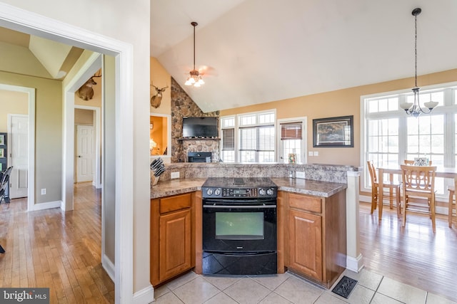 kitchen with hanging light fixtures, black electric range oven, high vaulted ceiling, ceiling fan with notable chandelier, and light hardwood / wood-style floors