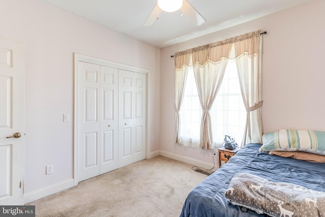 carpeted bedroom featuring ceiling fan and a closet