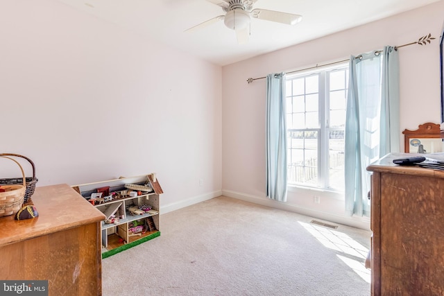 rec room with light carpet, ceiling fan, and a wealth of natural light