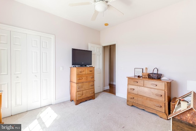 carpeted bedroom featuring ceiling fan and a closet