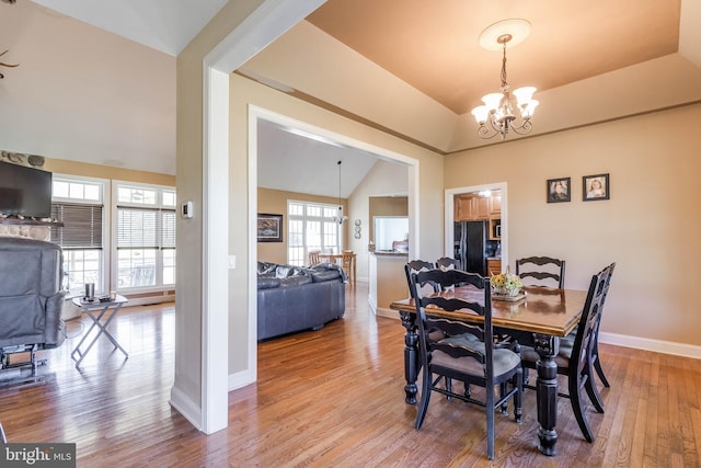 dining area featuring plenty of natural light, vaulted ceiling, and hardwood / wood-style flooring