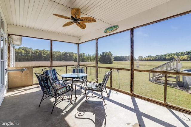 sunroom / solarium with a rural view and ceiling fan