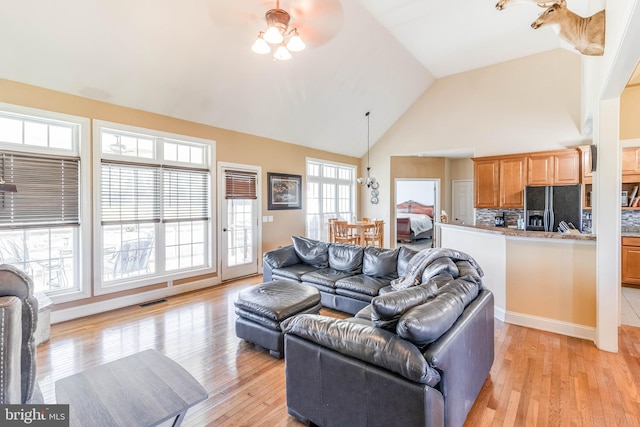 living room featuring high vaulted ceiling, ceiling fan, and light hardwood / wood-style floors