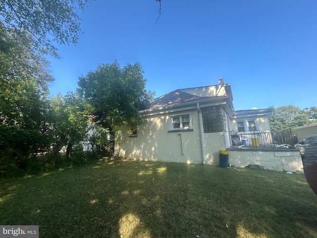 view of side of home with a lawn