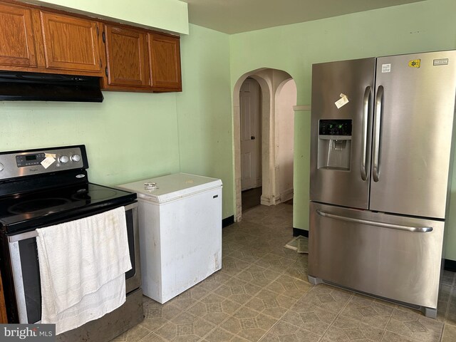 kitchen featuring stainless steel appliances and range hood