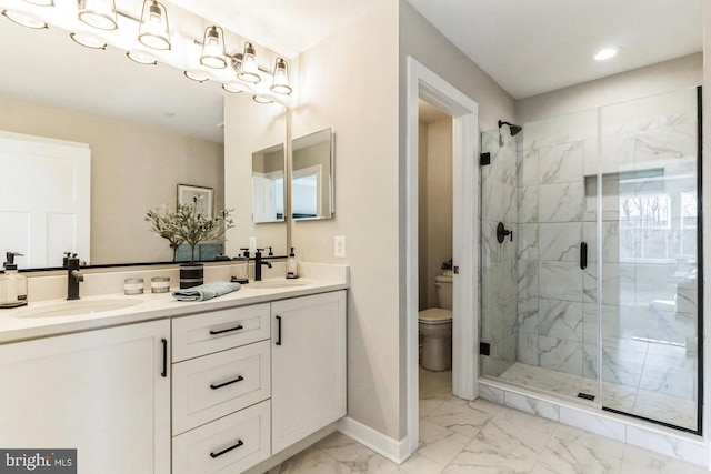 bathroom with vanity, a shower with door, and toilet