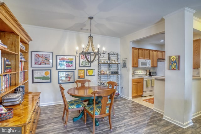 dining space featuring ornamental molding, a chandelier, and dark wood-type flooring