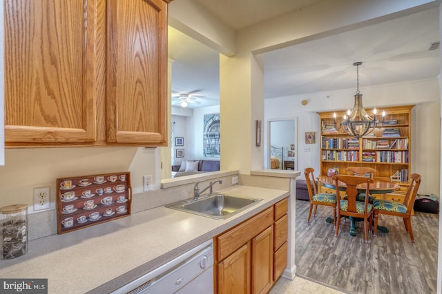 kitchen with ceiling fan with notable chandelier, hanging light fixtures, light hardwood / wood-style floors, and sink