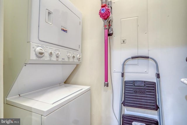 clothes washing area featuring stacked washer and dryer