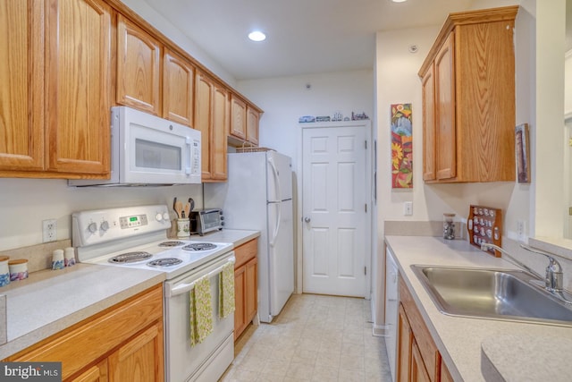 kitchen featuring white appliances and sink