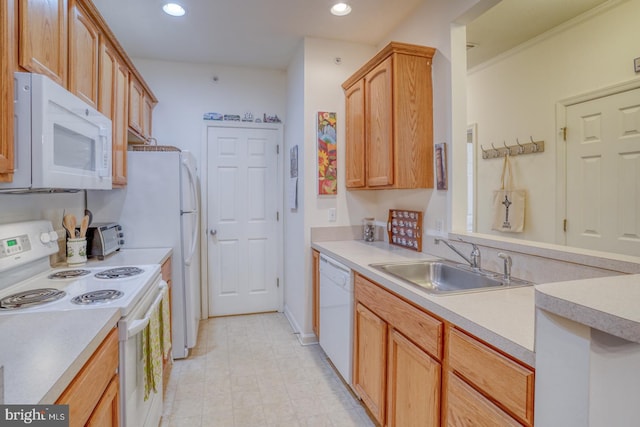 kitchen featuring white appliances, sink, and light brown cabinetry