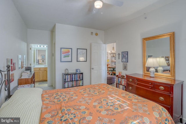 bedroom with ceiling fan with notable chandelier and ensuite bath