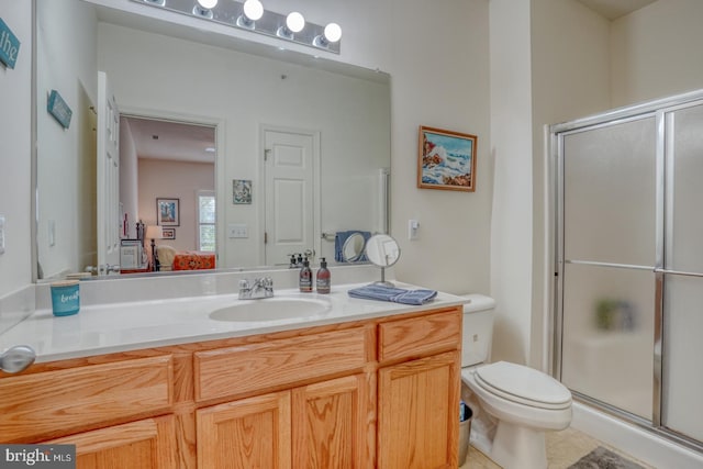 bathroom with a shower with door, tile patterned floors, vanity, and toilet