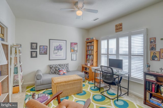 office space featuring light carpet and ceiling fan