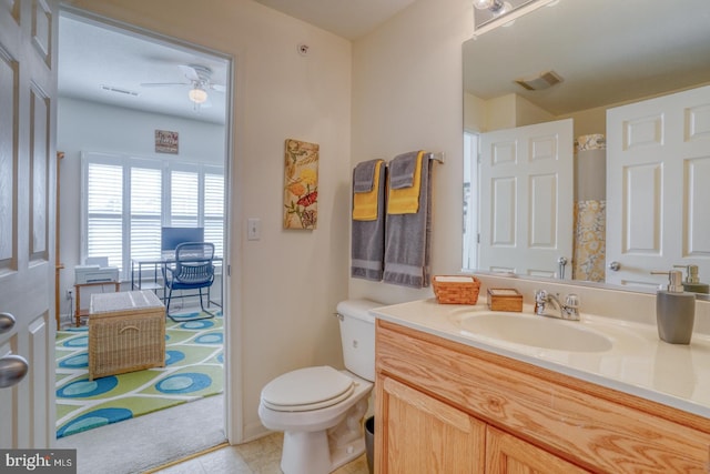 bathroom featuring ceiling fan, vanity, tile patterned flooring, and toilet