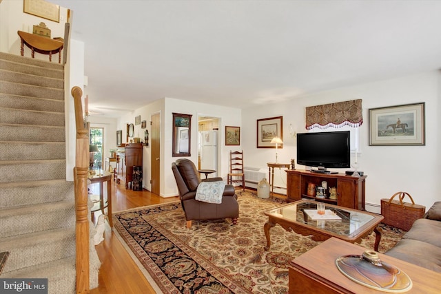 living room with light hardwood / wood-style flooring and a baseboard heating unit