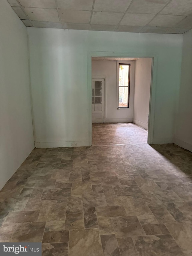 unfurnished room featuring a drop ceiling